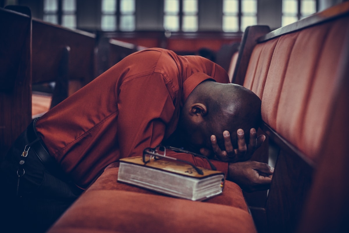 Person praying with Bible in church